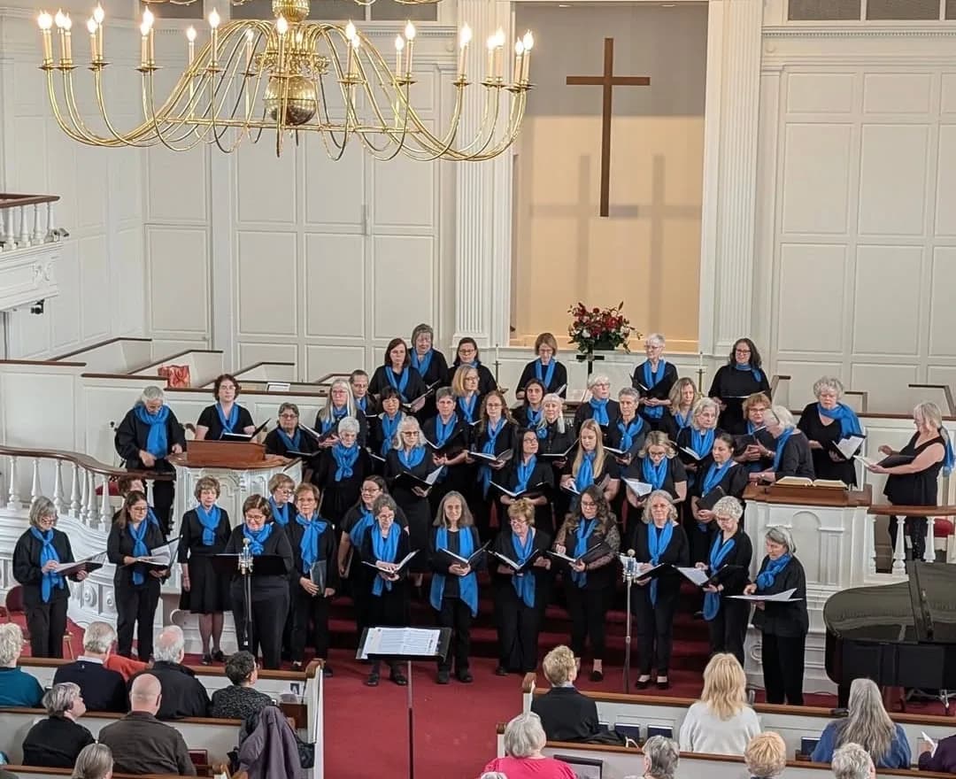 The Second Baptist Church choir in blue scarves singing in the sanctuary beneath the chandelier